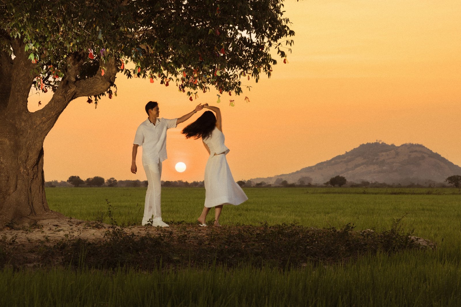 Vireak and Mony dancing together at golden hour in the Cambodian countryside